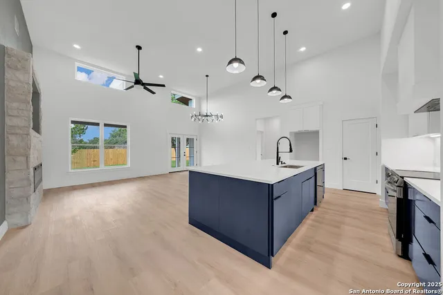 a kitchen with kitchen island a sink a stove and a wooden floor