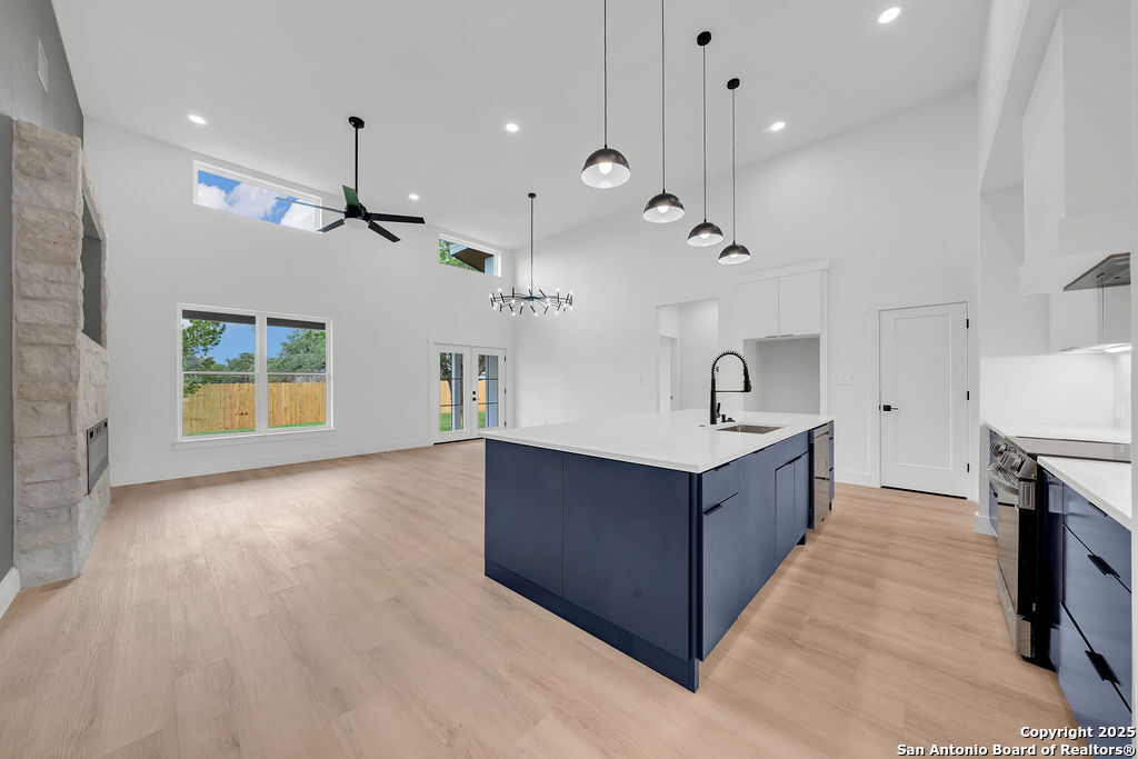 661 Jonquil Drive Spring Branch, TX 78070 - Photo 6 of 18 a kitchen with kitchen island a sink a stove and a wooden floor