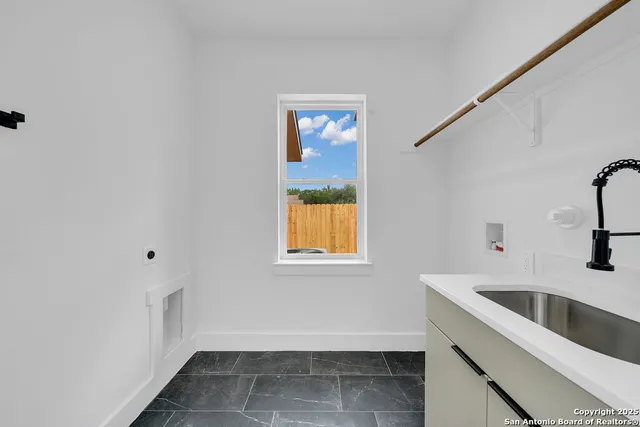 a view of a kitchen that shows a sink and dishwasher with wooden floor