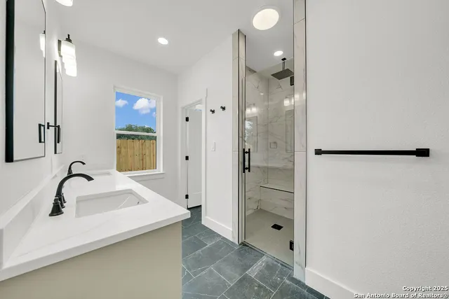 a bathroom with a shower sink and mirror
