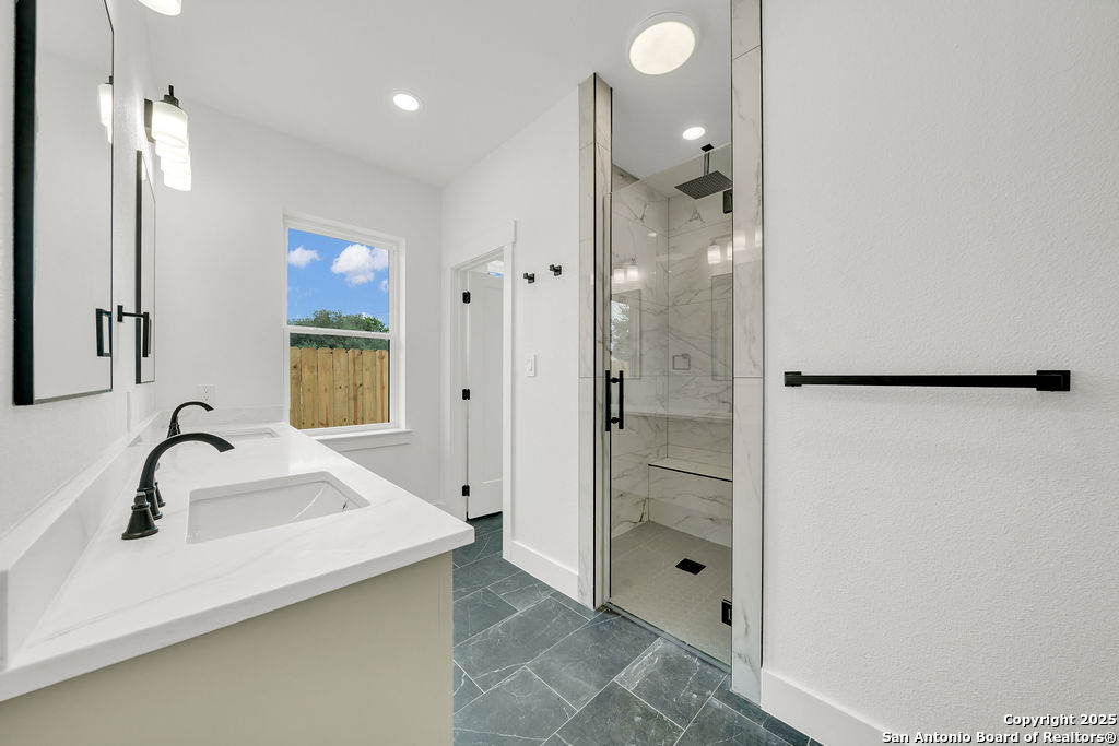 661 Jonquil Drive Spring Branch, TX 78070 - Photo 10 of 18 a bathroom with a shower sink and mirror