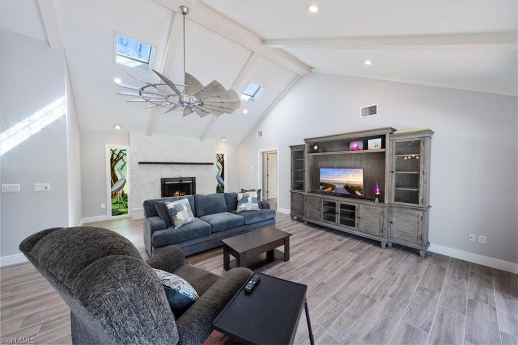 4231-4241 Orange River Loop Road Fort Myers, FL 33905 - Photo 16 of 50 a living room with furniture a flat screen tv and a fireplace