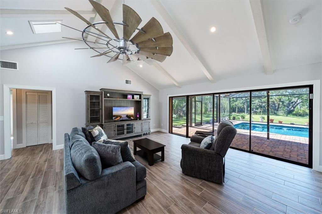 4231-4241 Orange River Loop Road Fort Myers, FL 33905 - Photo 17 of 50 a living room with furniture a fireplace and a floor to ceiling window