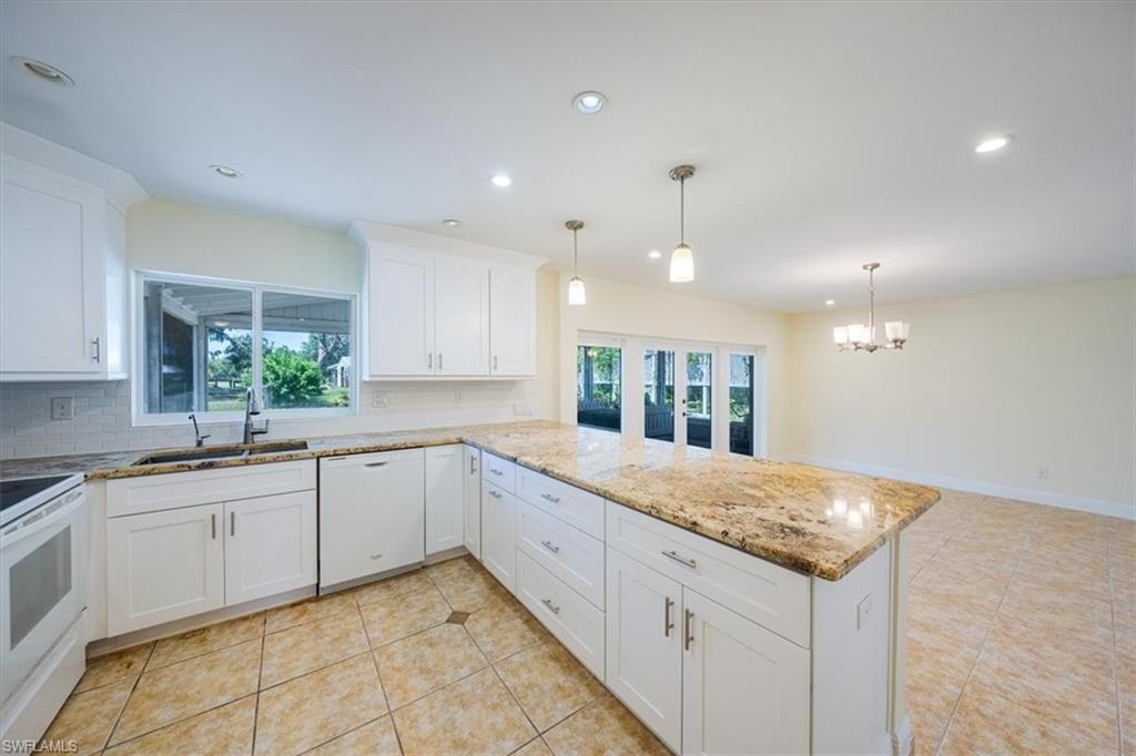 4231-4241 Orange River Loop Road Fort Myers, FL 33905 - Photo 35 of 50 a large kitchen with granite countertop a sink and white cabinets
