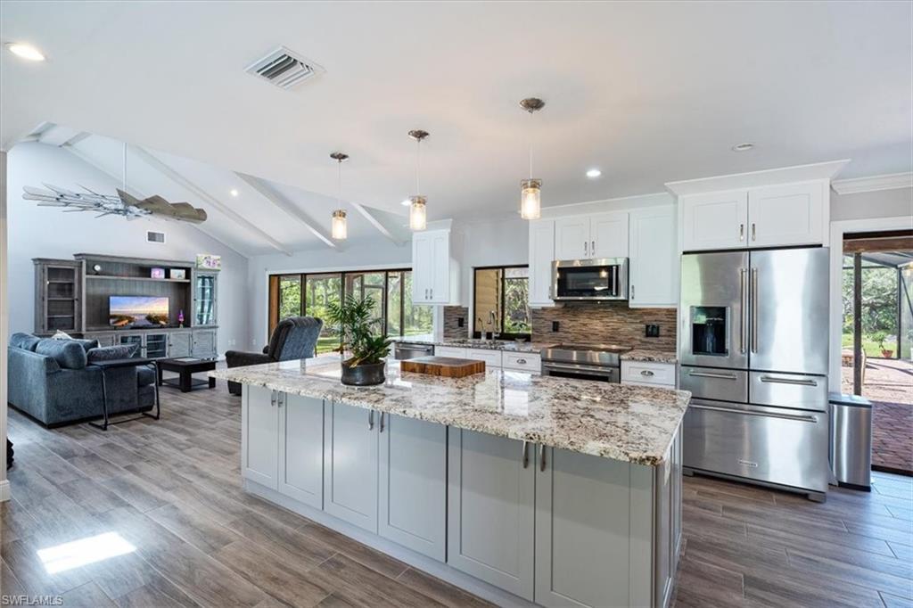 4231-4241 Orange River Loop Road Fort Myers, FL 33905 - Photo 4 of 50 a kitchen with refrigerator and cabinets