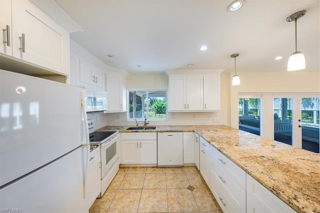 4231-4241 Orange River Loop Road Fort Myers, FL 33905 - Photo 44 of 50 a large kitchen with granite countertop a sink and white cabinets