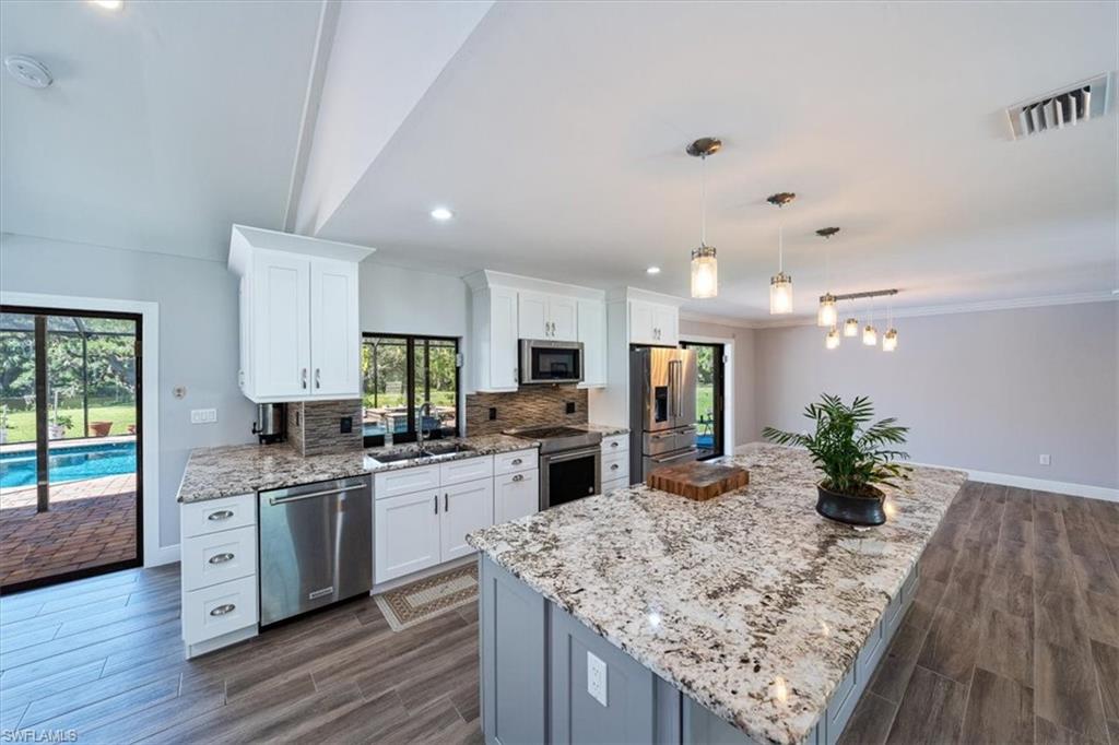 4231-4241 Orange River Loop Road Fort Myers, FL 33905 - Photo 6 of 50 a kitchen with stainless steel appliances granite countertop sink stove top oven and cabinets