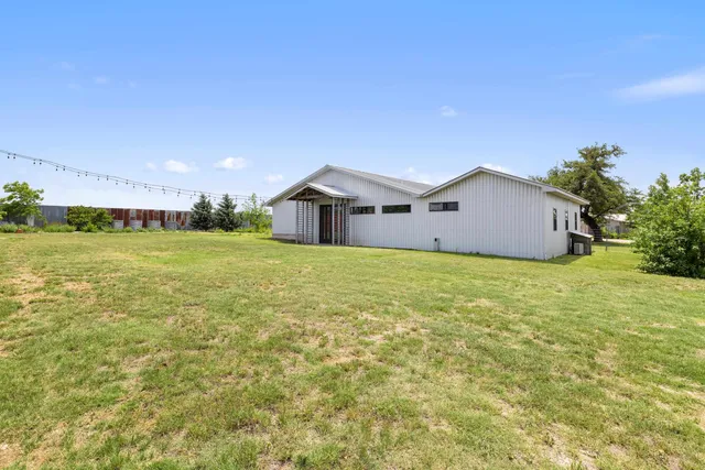 a view of a house with a big yard and large trees