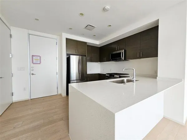 a view of kitchen with stainless steel appliances a refrigerator and a microwave