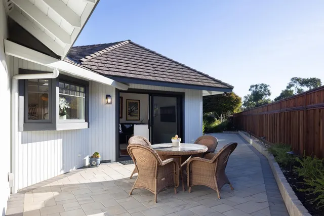 a view of a patio with table and chairs and wooden fence