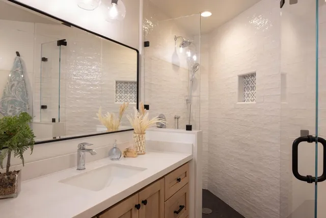 a bathroom with a double vanity sink a mirror and a shower
