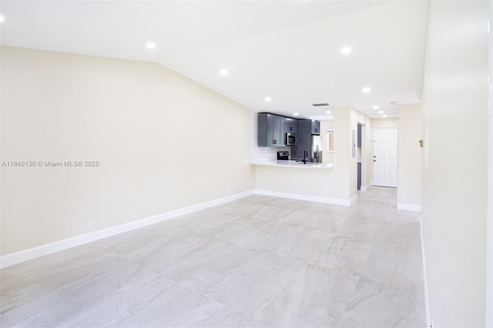 9431 Boca Cove Circle, Unit 1009 Boca Raton, FL 33428 - Photo 11 of 30 a view of a kitchen with a refrigerator and a sink