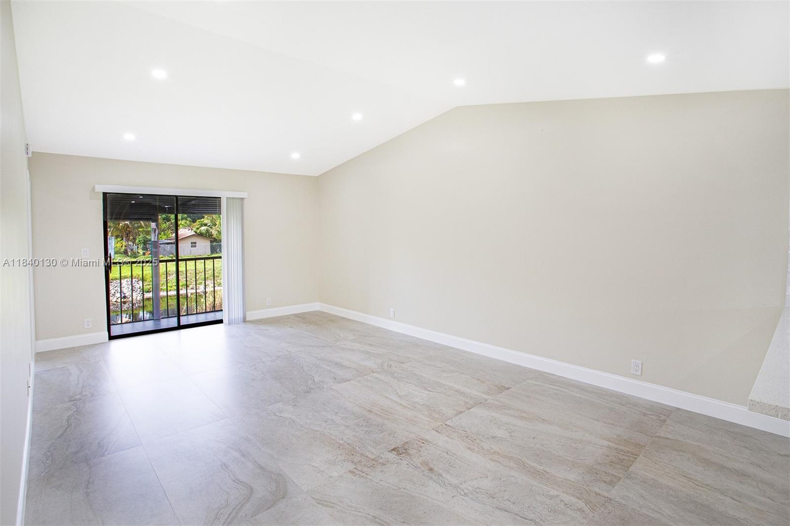 9431 Boca Cove Circle, Unit 1009 Boca Raton, FL 33428 - Photo 12 of 30 an empty room with wooden floor and windows