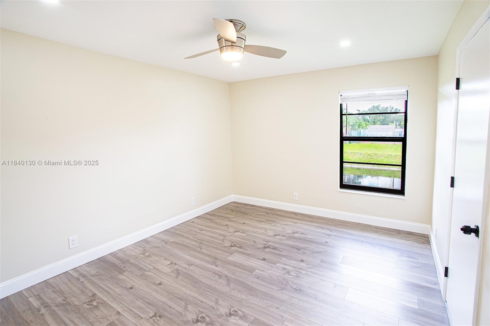9431 Boca Cove Circle, Unit 1009 Boca Raton, FL 33428 - Photo 15 of 30 an empty room with a window and wooden floor