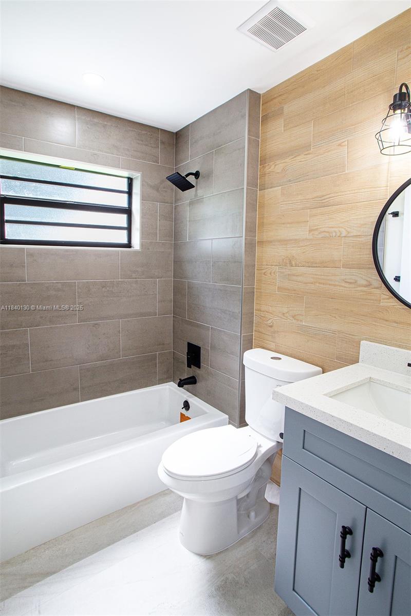 9431 Boca Cove Circle, Unit 1009 Boca Raton, FL 33428 - Photo 16 of 30 a bathroom with a sink a toilet and a bathtub