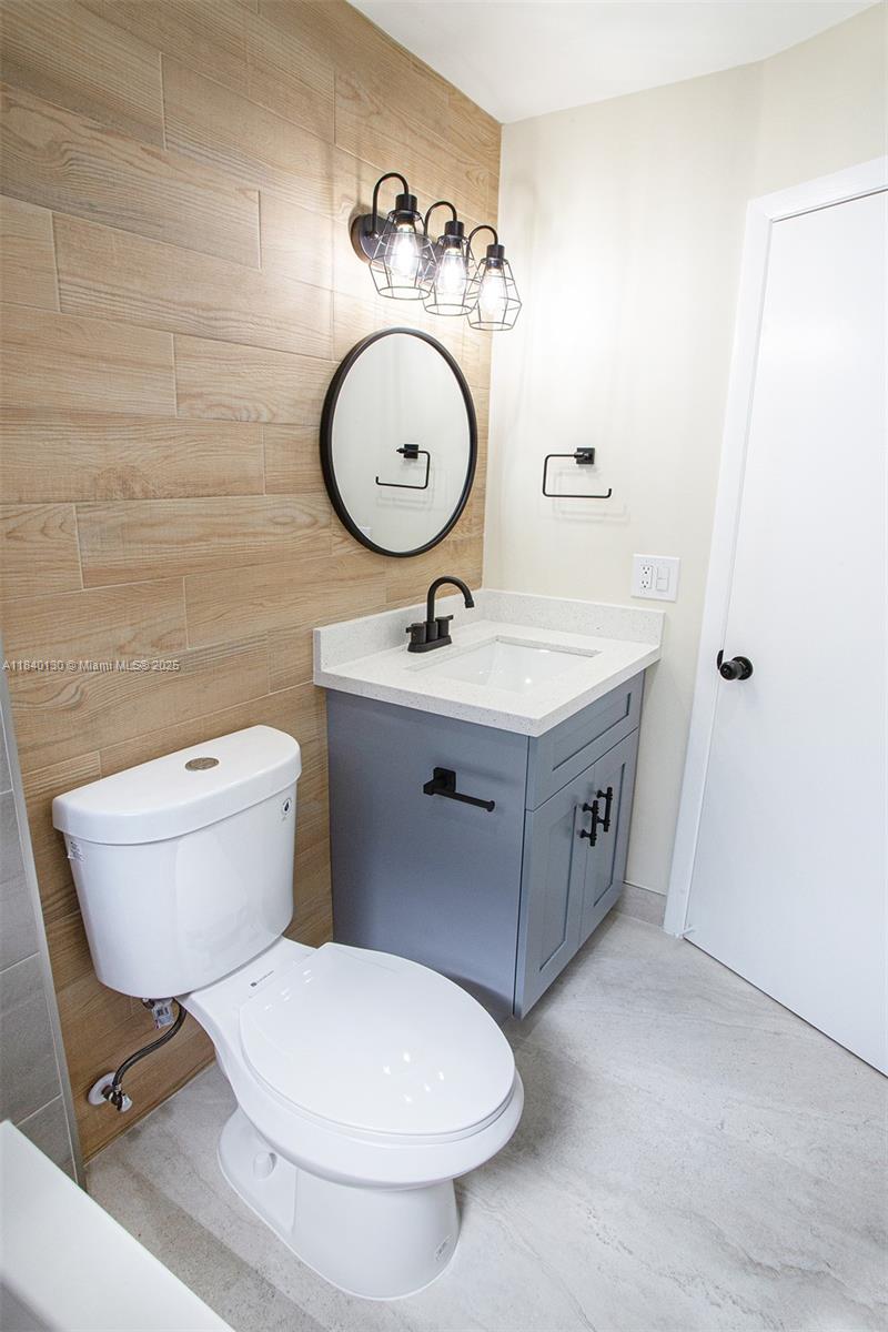 9431 Boca Cove Circle, Unit 1009 Boca Raton, FL 33428 - Photo 17 of 30 a bathroom with a toilet sink and mirror