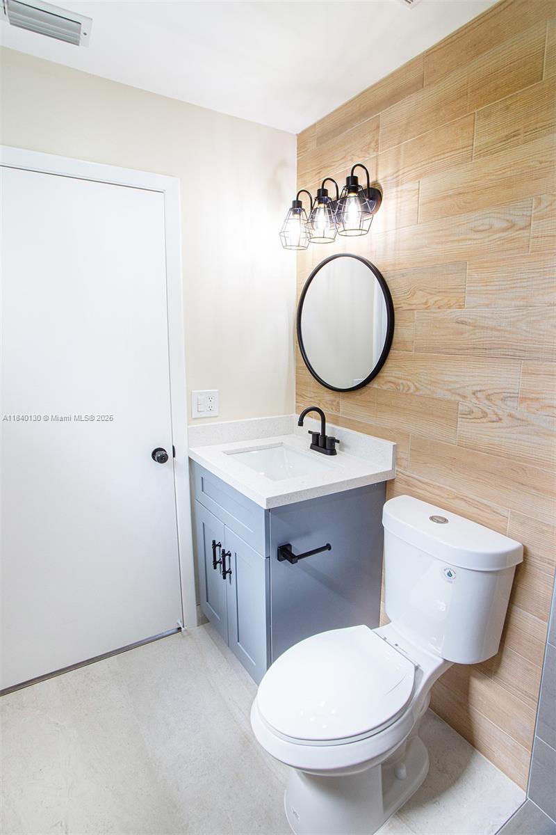 9431 Boca Cove Circle, Unit 1009 Boca Raton, FL 33428 - Photo 18 of 30 a bathroom with a toilet sink and mirror