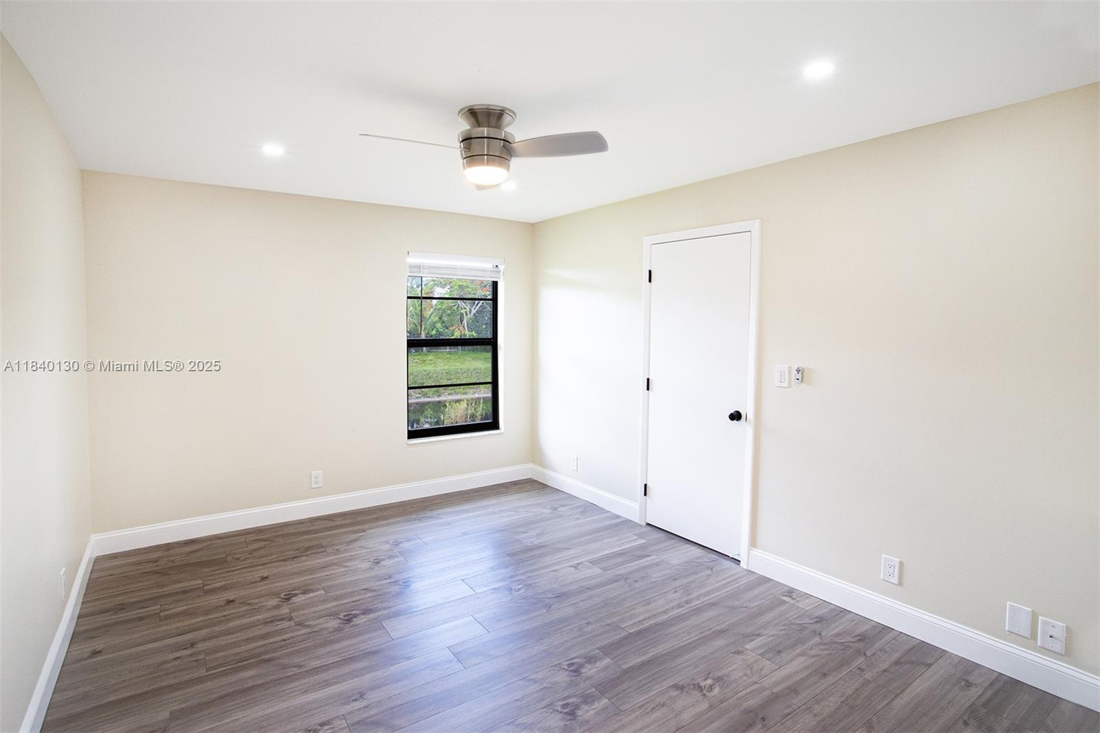 9431 Boca Cove Circle, Unit 1009 Boca Raton, FL 33428 - Photo 20 of 30 an empty room with wooden floor and windows