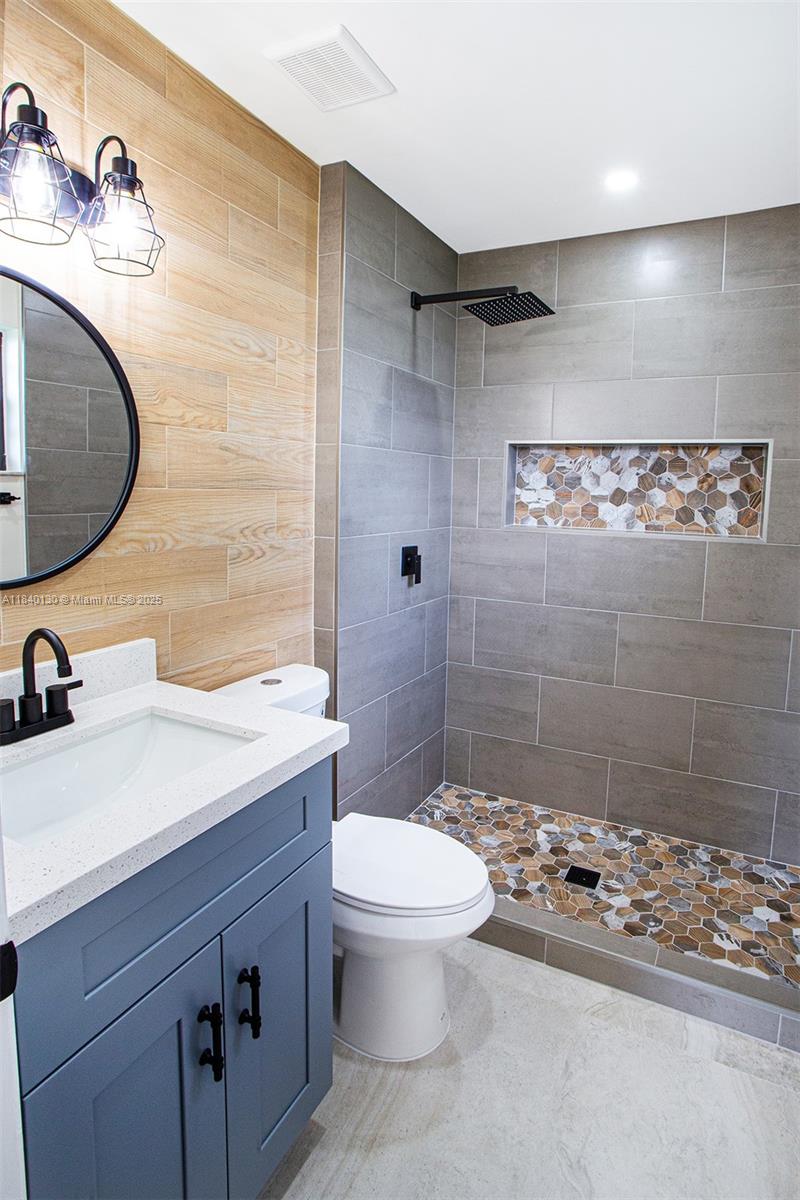 9431 Boca Cove Circle, Unit 1009 Boca Raton, FL 33428 - Photo 23 of 30 a bathroom with a sink a toilet and shower