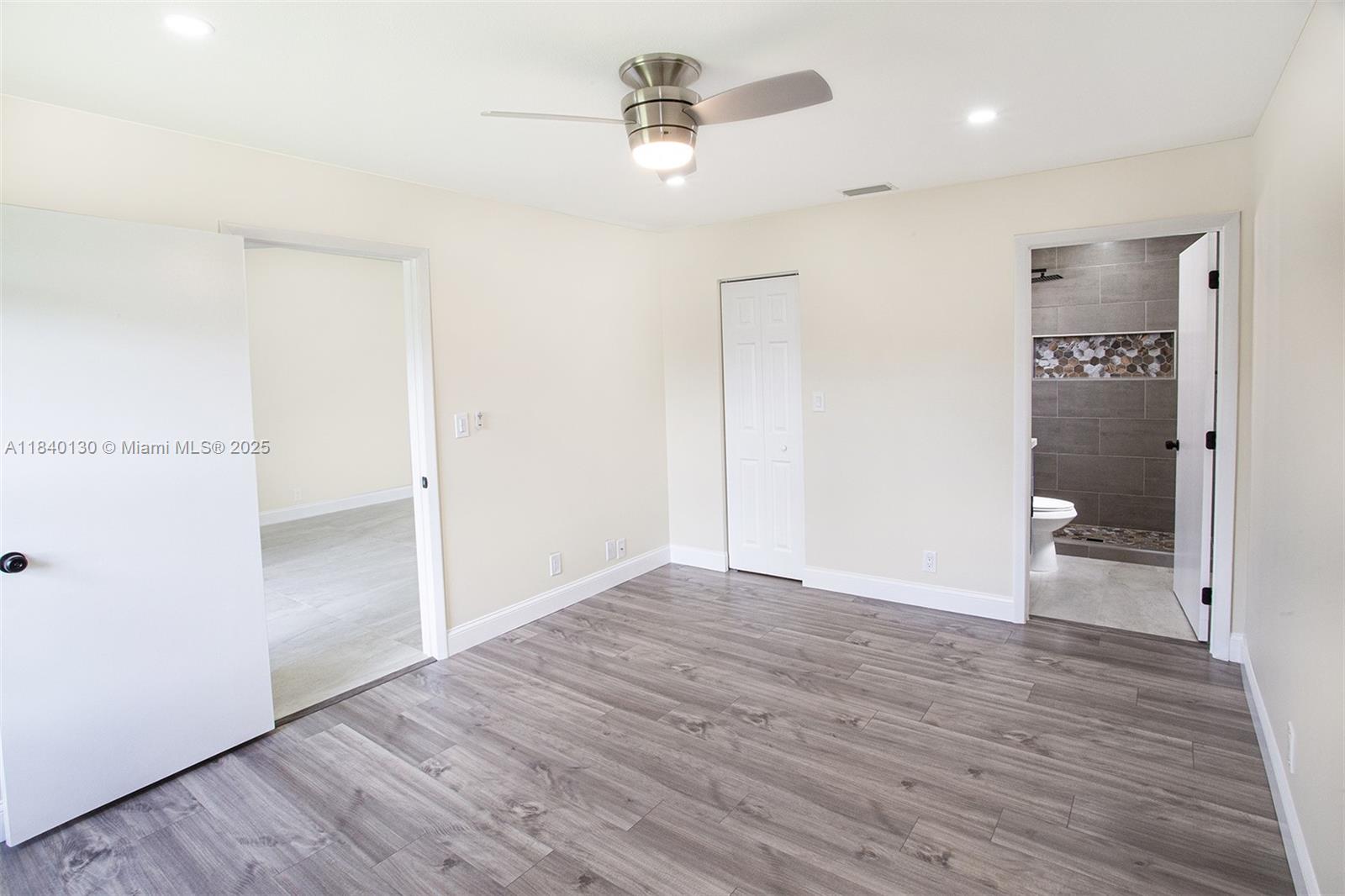 9431 Boca Cove Circle, Unit 1009 Boca Raton, FL 33428 - Photo 24 of 30 an empty room with wooden floor and ceiling fan