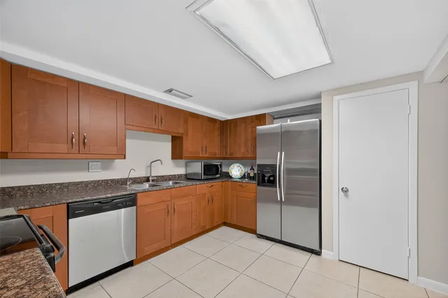 a kitchen with stainless steel appliances granite countertop a refrigerator and a sink