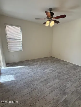 an empty room with a ceiling fan and window