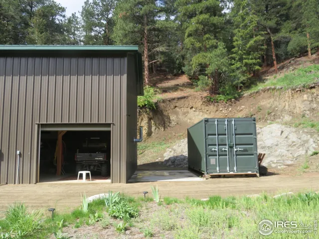 a view of a house with a small yard and a large tree
