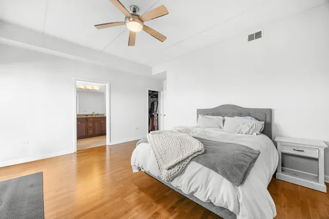 a spacious bedroom with a bed and a chandelier