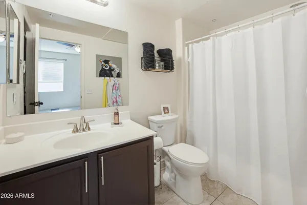 a bathroom with a sink a toilet a mirror and shower curtain