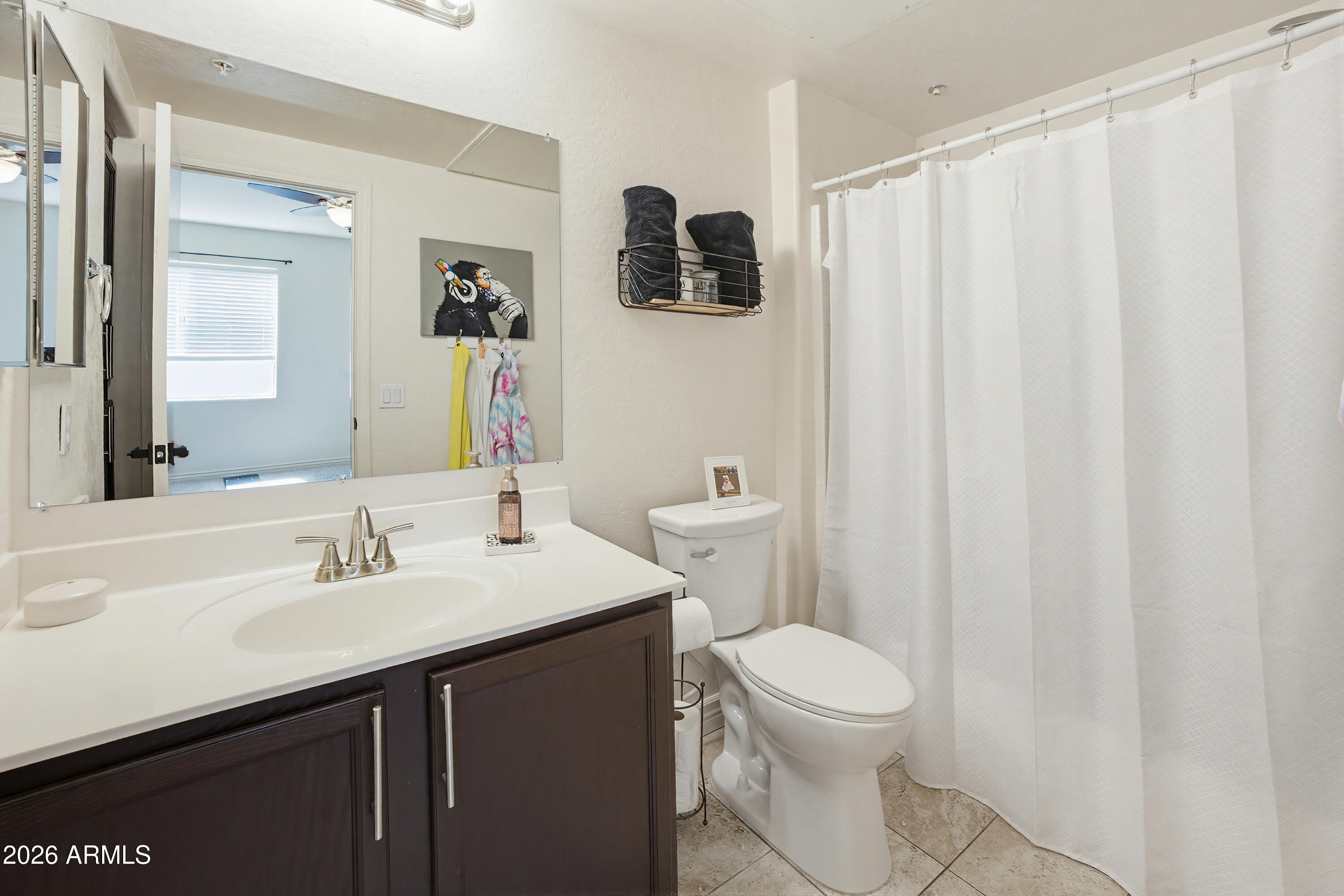 3250 West Greenway Road, Unit 162 Phoenix, AZ 85053 - Photo 24 of 31 a bathroom with a sink a toilet a mirror and shower curtain