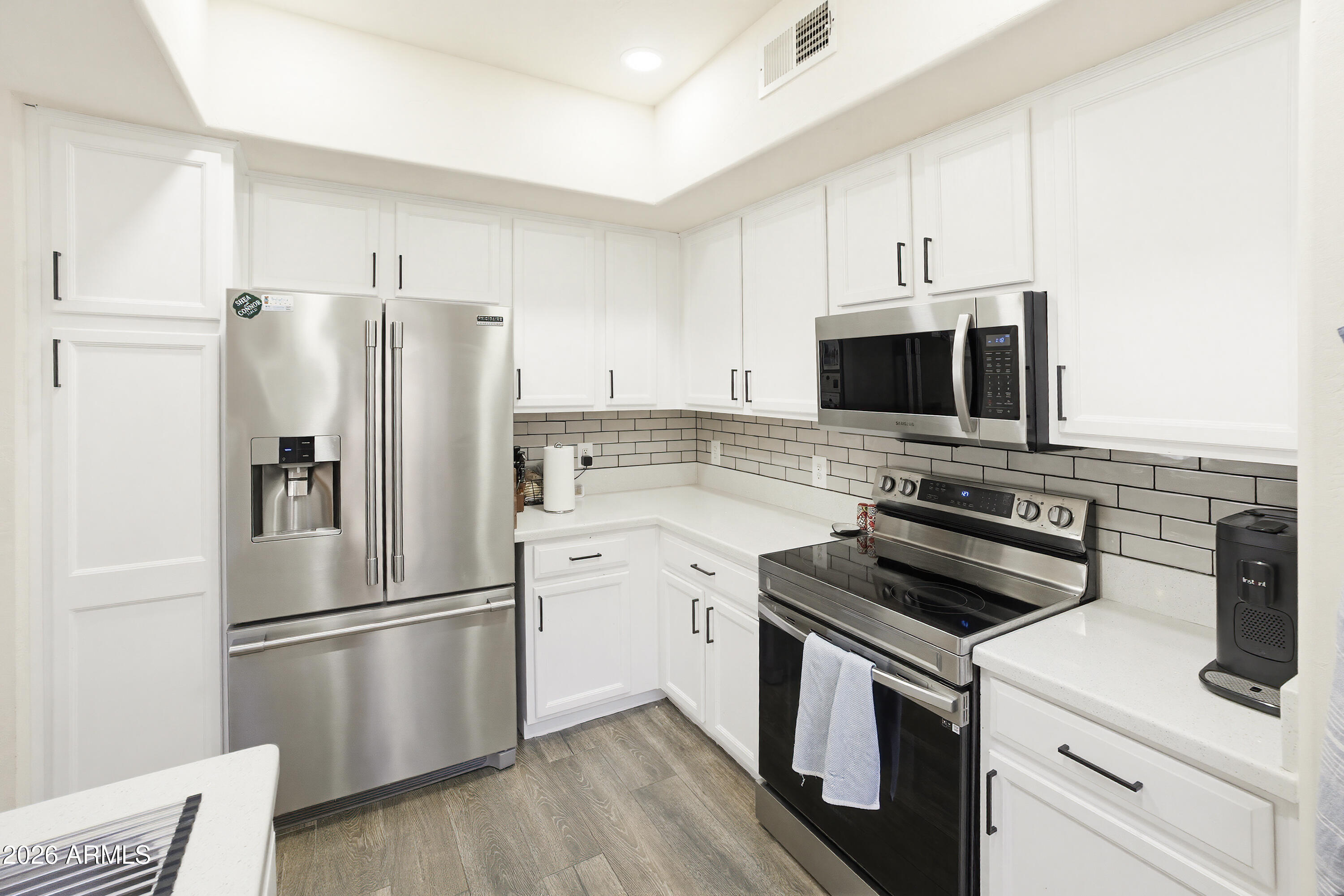 3250 West Greenway Road, Unit 162 Phoenix, AZ 85053 - Photo 6 of 31 a kitchen with cabinets stainless steel appliances and wooden floor