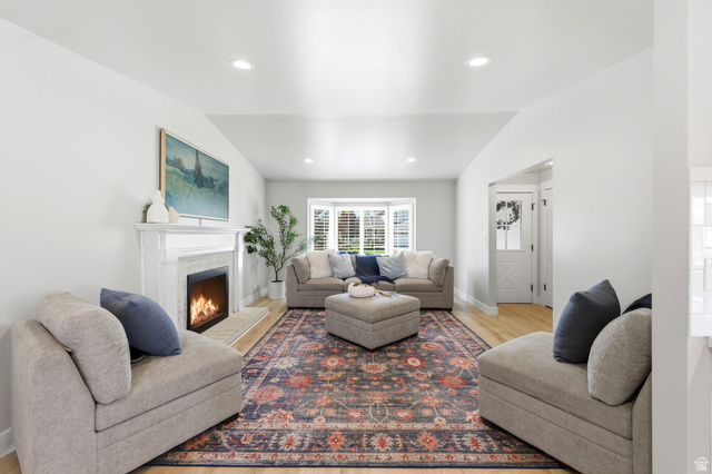 1405 Vintry Lane Murray, UT 84121 - Photo 6 of 44 Living area featuring a white mantel fireplace with a tiled surround, recessed lighting, wood-finish flooring, and a bay window with plantation shutters