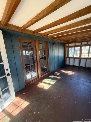 a view of an empty room with wooden floor and a fireplace