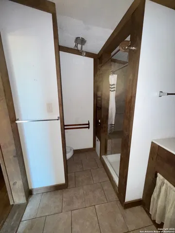 a view of an empty room with wooden floor and furniture