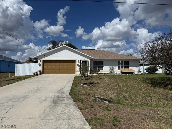 a front view of a house with a yard and trees