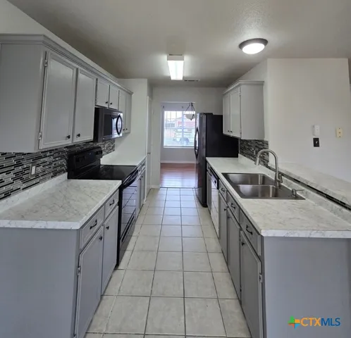 a kitchen with a sink stove top oven and cabinets