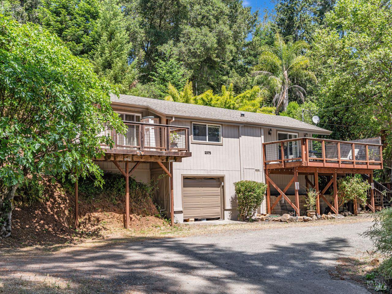 a front view of a house with a tree