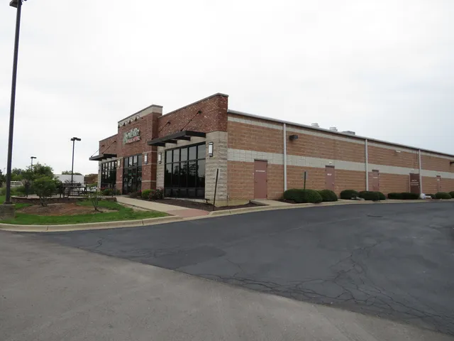 a view of a green field with wooden fence