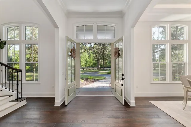 a kitchen with kitchen island granite countertop a stove a sink a refrigerator and white cabinets with wooden floor