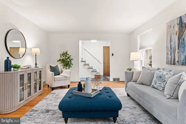 a living room with furniture a wooden floor and a large window