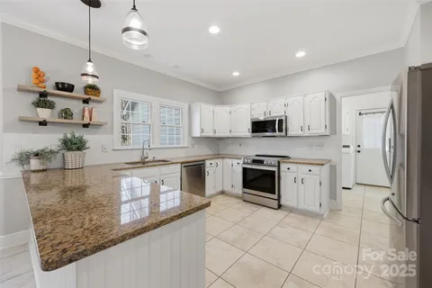 a kitchen with stainless steel appliances granite countertop a stove a sink and a refrigerator