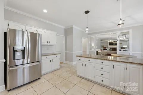 a kitchen with granite countertop white cabinets and stainless steel appliances