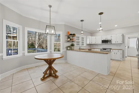 a kitchen with stainless steel appliances kitchen island granite countertop a table chairs in it and wooden floors