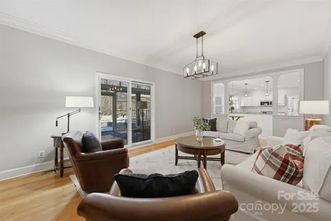a living room with furniture and a chandelier