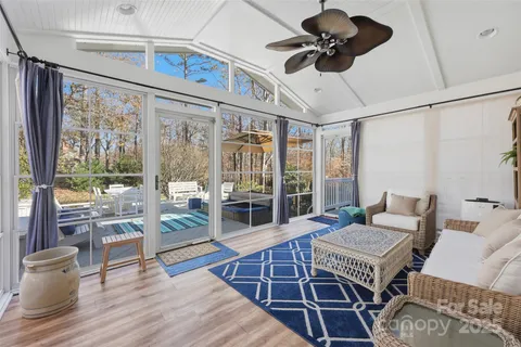 a living room with furniture a flat screen tv and a large window