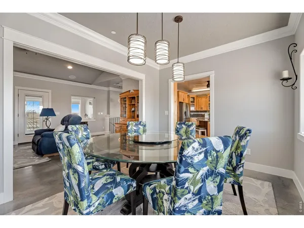a kitchen with stainless steel appliances kitchen island granite countertop a table chairs sink and cabinets