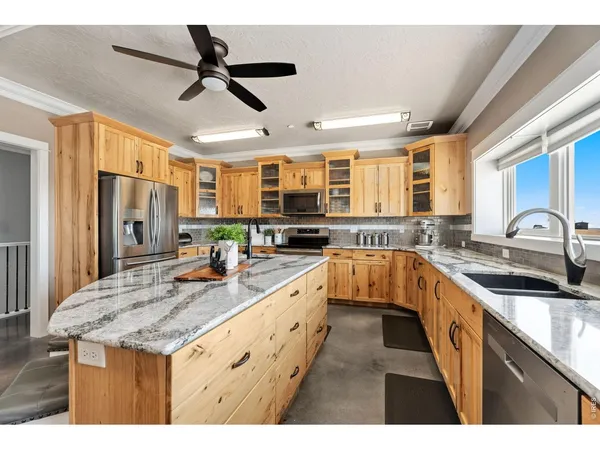 a large kitchen with granite countertop a sink and a large window