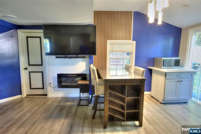 a living room with furniture a flat screen tv and kitchen view