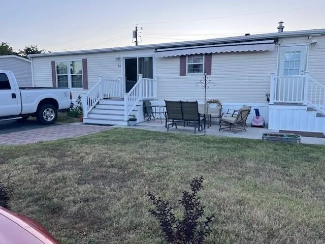 a view of a house with a backyard and chairs