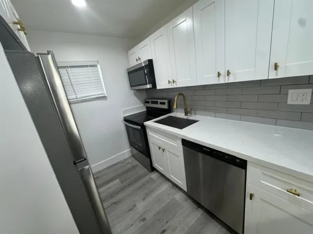 a kitchen with a sink stove and refrigerator